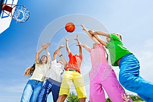 I bambini a giocare a basket insieme con una palla in cielo, vista dal basso.