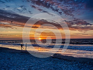 Kids playing on the beach at sunrise