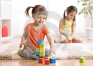 Kids playing block toys in playroom at nursery