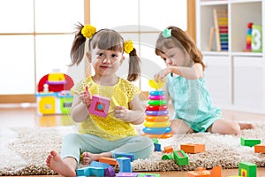 Kids playing with blocks together. Educational toys for preschool and kindergarten child. Little girls build toys at
