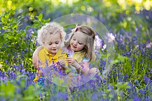 Kids playing in blooming garden with bluebell flowers