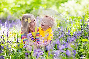 Kids playing in blooming garden with bluebell flowers