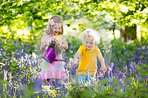 Kids playing in blooming garden with bluebell flowers