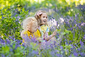 Kids playing in blooming garden with bluebell flowers