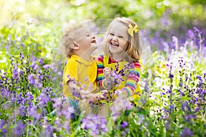 Kids playing in blooming garden with bluebell flowers