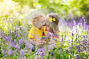 Kids playing in blooming garden with bluebell flowers