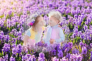 Kids playing in blooming garden with hyacinth flowers