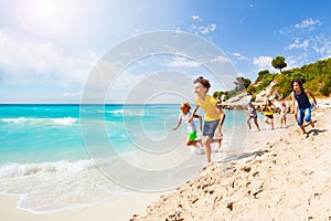 Kids playing catch-up on sandy beach