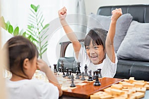 Kids playing chess - one of them just captured a pawn and celebrates