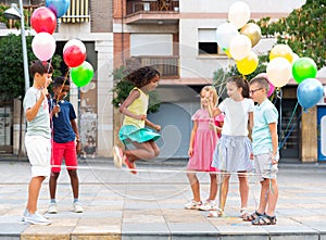 Kids playing with Chinese jumping rope outdoors