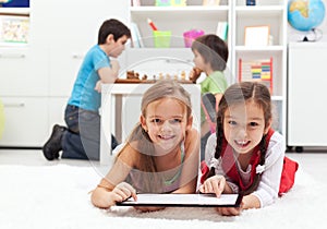 Kids playing classic board games and modern tablet computer game