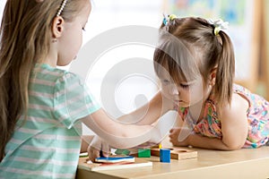 Kids playing with colorful block toys. Two children girls at home or daycare center. Educational child toys for