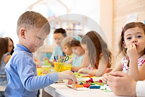 Kids playing with colorful clay at kindergarten