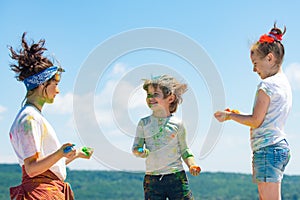 Kids playing colours. Holi festival of colors. Kids with face smeared with colors. Child girls and boy celebrate Indian