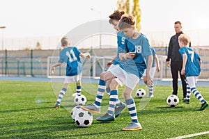 Kids playing and competing on sports soccer training. Happy children kicking balls