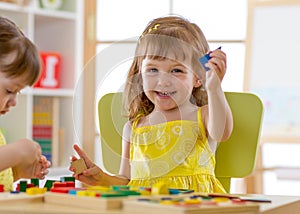 Kids playing with developmental toys at home or kindergarten or daycare center