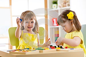 Kids playing with developmental toys at home or kindergarten or playschool photo