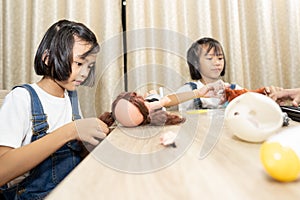 Kids playing doll and stay at home, children funny and joyful on table,
