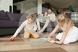 Kids playing drawing at home, family spending leisure time toget