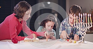 Kids playing with dreidels during Hanukka at home