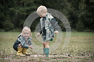 Kids playing games in camp on rainy day dressed in raincoats