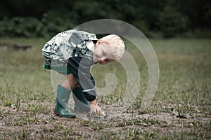 Kids playing games in camp on rainy day dressed in raincoats