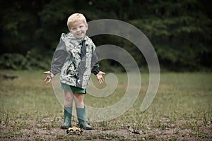 Kids playing games in camp on rainy day dressed in raincoats