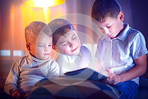 Kids playing games on tablet pc. Three little boys with tablet computer