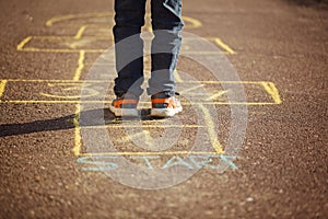 Kids playing hopscotch on playground outdoors. Hopscotch popular street game