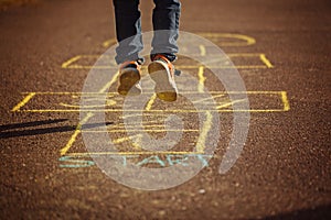 Kids playing hopscotch on playground outdoors. Hopscotch popular street game.