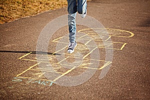 Kids playing hopscotch on playground outdoors. Hopscotch popular street game