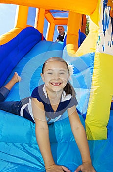 Kids playing on an inflatable slide bounce house