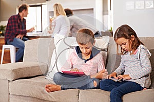 Kids playing with new technology while adults entertain