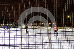 Kids playing outdoor hockey on ice at night in a park of Quebec, Canada - 1/3