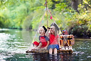 Kids playing pirate adventure on wooden raft photo