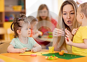 Kids playing with play clay in kindergarten or playschool