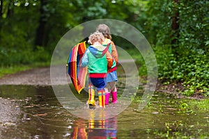 Kids playing in the rain with umbrella