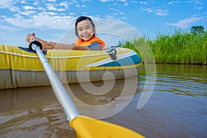 Kids playing and rowing boat in river of organic farm in rural on blue sky and white clouds background
