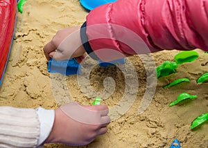 Kids playing sand and plastic mould