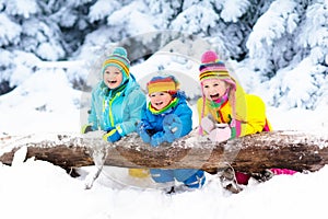 Kids playing in snow. Children play outdoors in winter snowfall.