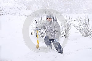 Kids playing in snow. Children play outdoors on snowy winter day. Child with shovel playing outdoors in winter season