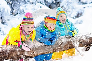 Kids playing in snow. Children play outdoors in winter snowfall.