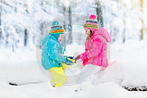 Kids playing in snow. Children play outdoors in winter snowfall.