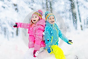 Kids playing in snow. Children play outdoors in winter snowfall.