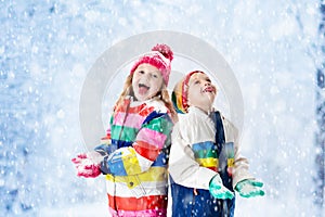 Kids playing in snow. Children play outdoors in winter snowfall.