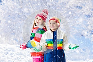 Kids playing in snow. Children play outdoors in winter snowfall