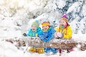 Kids playing in snow. Children play outdoors in winter snowfall