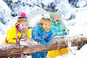 Kids playing in snow. Children play outdoors in winter snowfall.