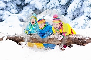 Kids playing in snow. Children play outdoors in winter snowfall.