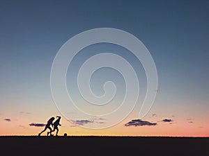 Kids playing soccer at sunset